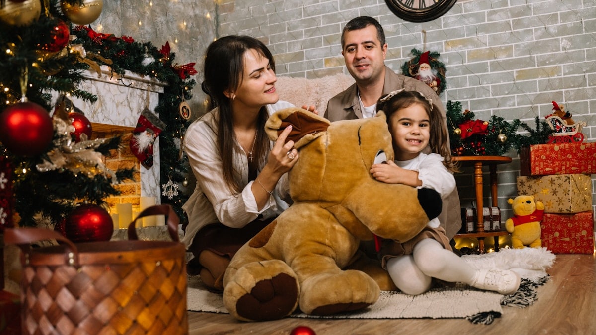 A family sitting on the floor in front of a christmas tree